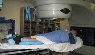 The author positioned for radiation treatment under a linear accelerator. The author positioned for radiation treatment under a linear accelerator.